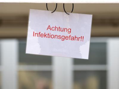 Ein Schild mit der Aufschrift «Achtung Infektionsgefahr!» an einem Johanniter-Zelt in Brandenburg. Warnung