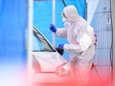 Ein Mitarbeiter führt in einem Corona-Abstrichzentrum einen Test durch. Coronavirus-Test