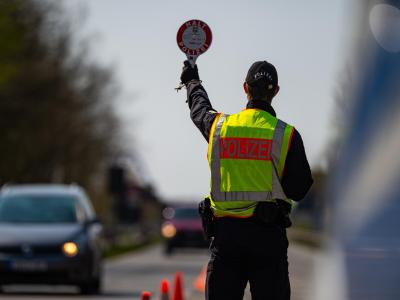 Ein Polizeibeamter kontrolliert hinter der Landesgrenze von Niedersachsen die Zufahrt nach Mecklenburg-Vorpommern. Coronavirus - Landesgrenze