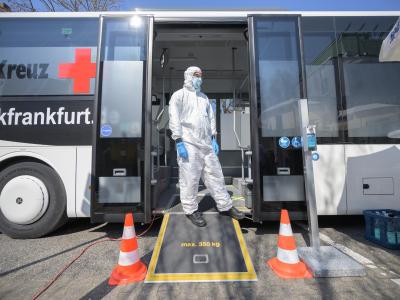 Ein Mitarbeiter steht vor einem Corona-Testmobil in Frankfurt am Main. Coronavirus - Testmobil