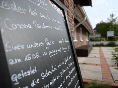 Ein Schild mit der Aufschrift «Leider hat auch uns die Corona Pandemie erreicht», steht vor dem Restaurant «Alte Scheune» in Moormerland. Restaurant in Niedersachsen