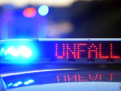 Auf einem Polizeifahrzeug warnt eine Leuchtschrift vor einer Unfallstelle. Polizeieinsatz