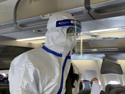 Ein Beamter der chinesischen Gesundheitsbehörde begleitet den Sonderflug, um die Körpertemperatur von Passagieren zu messen und nach Krankheitssymptomen zu fragen. Beamter der chinesischen Gesundheitsbehörde