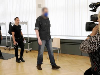 Justizmitarbeiter führen den 39-Jährigen in den Saal des Rostocker Landgerichts. Doppelmordprozess