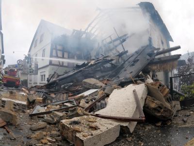 Feuerwehrleute und Rettungskräfte arbeiten an den Trümmern des explodierten Hauses in Weilrod-Riedelbach. Haustrümmer in Weilrod-Riedelbach